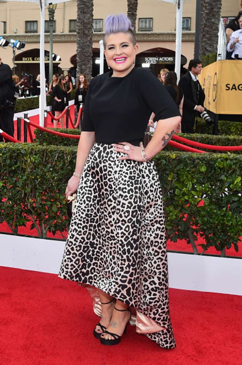 Kelly Osbourne escolheu um vestido com saia ampla em animal print e blusa preta. Não é para todas, nem para ela. Ampliou demais os quadris