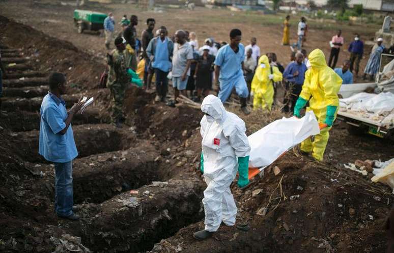 <p>Profissionais de sa&uacute;de enterram v&iacute;tima de Ebola em Freetown, Serra Leoa, em 17 de dezembro</p>