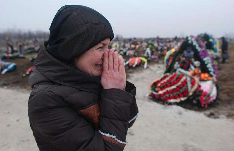 Familiar de vítima de bombardeio em cemitério de Mariupol. 27/01/2015