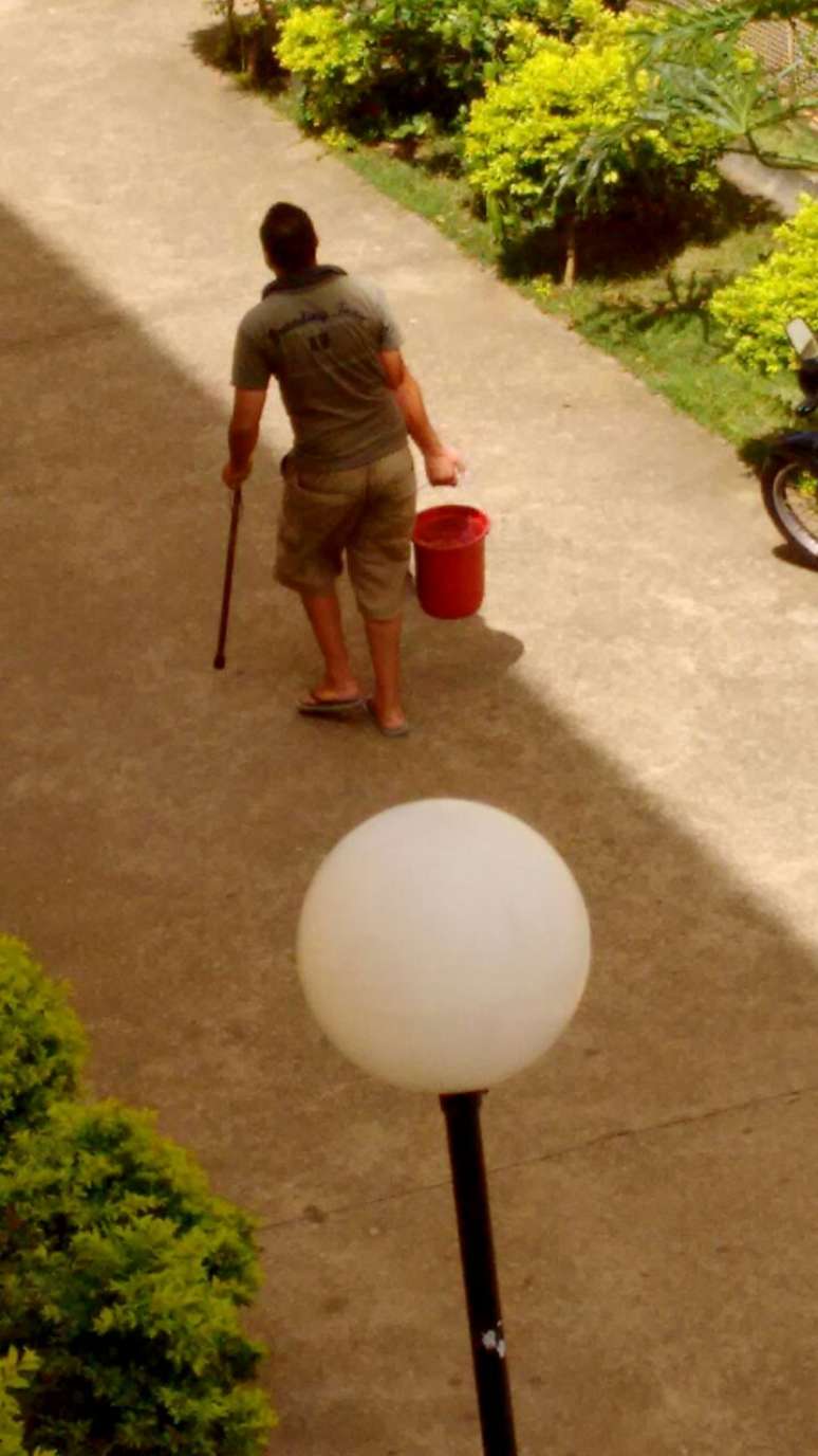 <p>Homem carrega água em balde para abastecer sua cada</p>