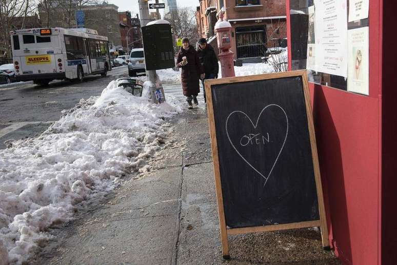 <p>Restaurante com placa de aberto em calçada de New York</p>