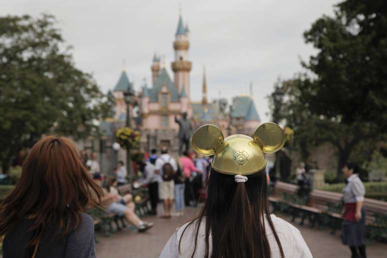 Una mujer con un gorro de Mickey Mouse camina hacia el Castillo de la Bella Durmiente en Disneyland el jueves, 22 de enero del 2015.