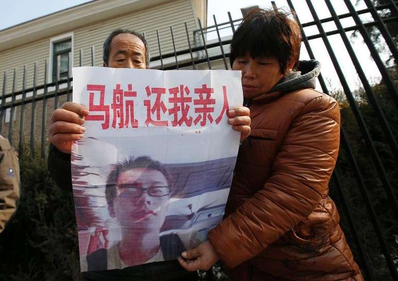 A parent whose son was onboard the missing Malaysia Airlines flight MH370, holds a poster featuring his son during a protest demanding the Malaysian government to keep searching the missing flight, in front of the Malaysian Embassy in Beijing January 29, 2015. Malaysia's Department of Civil Aviation will release an interim report on the investigation into the missing Malaysia Airlines Flight MH370 on March 7, a day before the one-year anniversary of the disappearance, deputy transport minister Aziz Kaprawi said on Wednesday. The words on the poster read, "Malaysia Airlines, return my loved one to me".