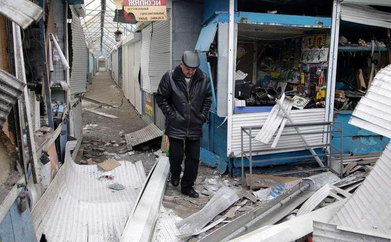 <p>Homem passa por loja danificada por recente ataque em mercado de Donetsk</p>