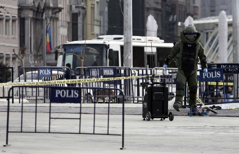 <p>Um especialista em desarmamento de bombas examina um pacote suspeito na Pra&ccedil;a Taksim, em Istambul,&nbsp;onde uma mulher abriu fogo contra um posto policial</p>