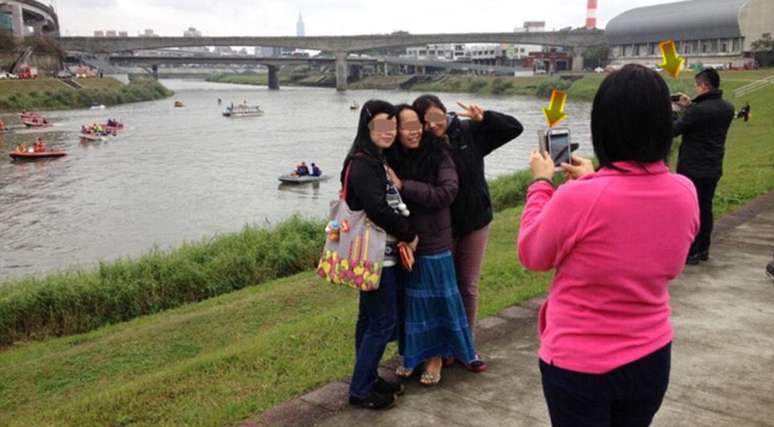 <p>Pessoas tiram foto em local de acidente sorrindo</p>