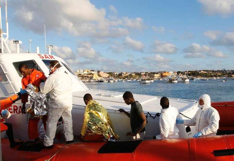 <p>Imigrantes resgatados no mar pela guarda costeira da It&aacute;lia chegam &agrave; ilha de Lampedusa nesta quarta-feira</p>