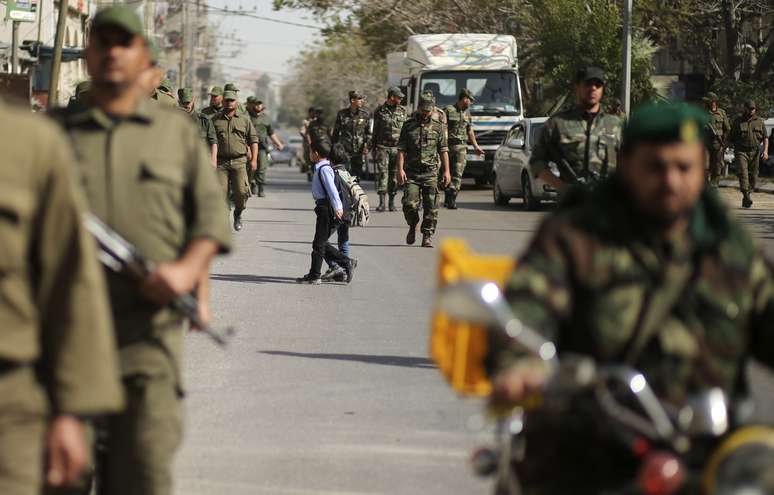 Crianças cruzam rua durante marcha de forças de segurança palestinas leais ao Hamas em Gaza, em 10 de fevereiro