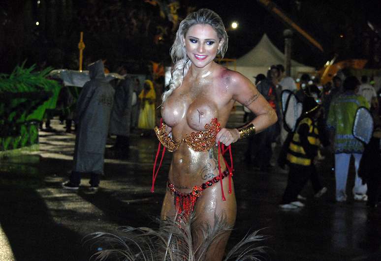<p>Modelo Junia Cabral, destaque da Peruche, se livra de fantasiaainda na dispersão do Sambódromo</p>