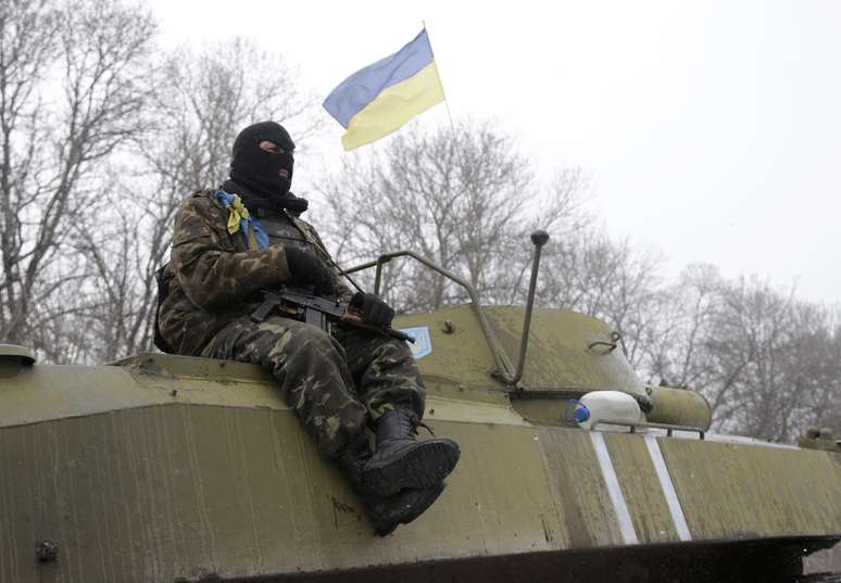 Um soldado ucraniano repousa sobre o seu veículo perto da estrada entre as cidades de Debaltseve e Artemivsk, na Ucrânia, em 16 de fevereiro