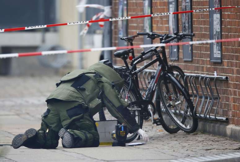 Especialista em desarmamento de bombas investiga um pacote deixado na frente do centro cultural alvo de um tiroteio em Copenhague, no ultimo sábado