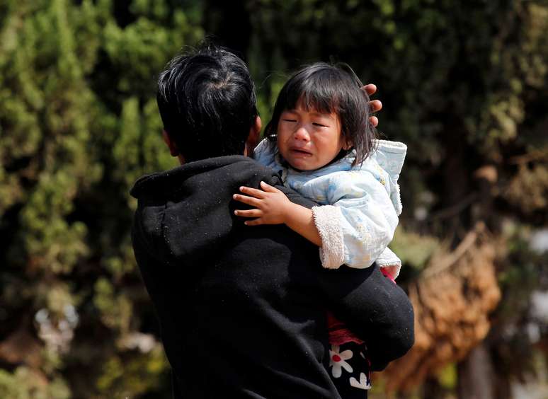 <p>Uma menina chora no ombro de seu pai enquanto eles esperam para ser evacuados por uma equipe de resgate volunt&aacute;rio ap&oacute;s os combates entre rebeldes e for&ccedil;as do governo, em Laukkai, em 17 fevereiro</p>