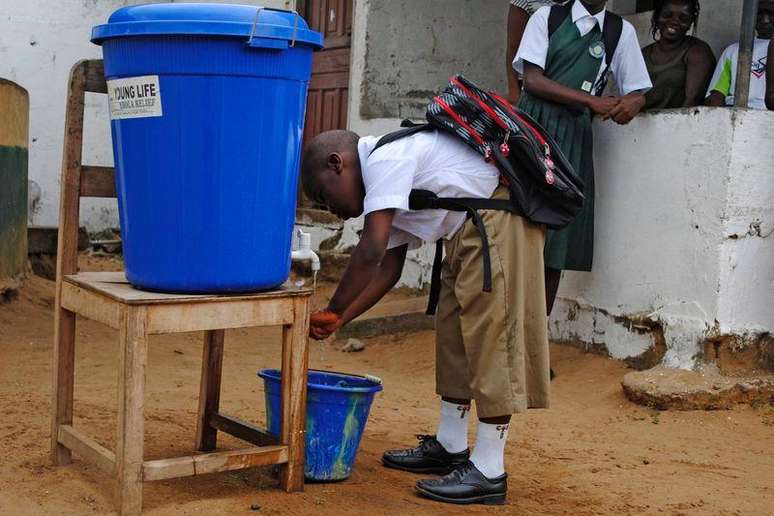 <p>Menino lava as mãos antes de ir para escola em Monróvia, na Libéria, como precaução contra Ebola</p>
