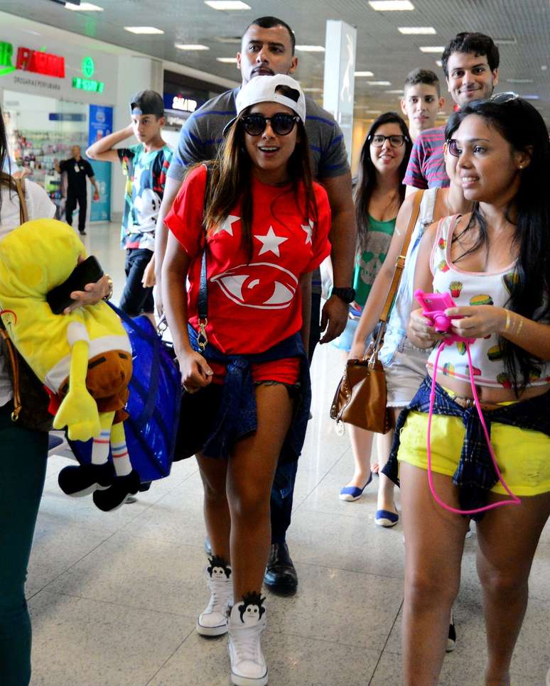 Anitta adora viajar de shorts tão curtos que desaparecem sob a camiseta. E mais boné virado, blusa amarrada na cintura e tênis sempre com algum detalhe. E quer saber? Está tudo legal na jovem cantora