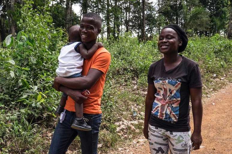 Musa Pabai segura o filho Oliver e caminha ao lado da namorada, Hannah Wright, após encontrá-los pela primeira vez desde sobreviver ao Ebola, em Walakor., na Libéria. 19/02/2015