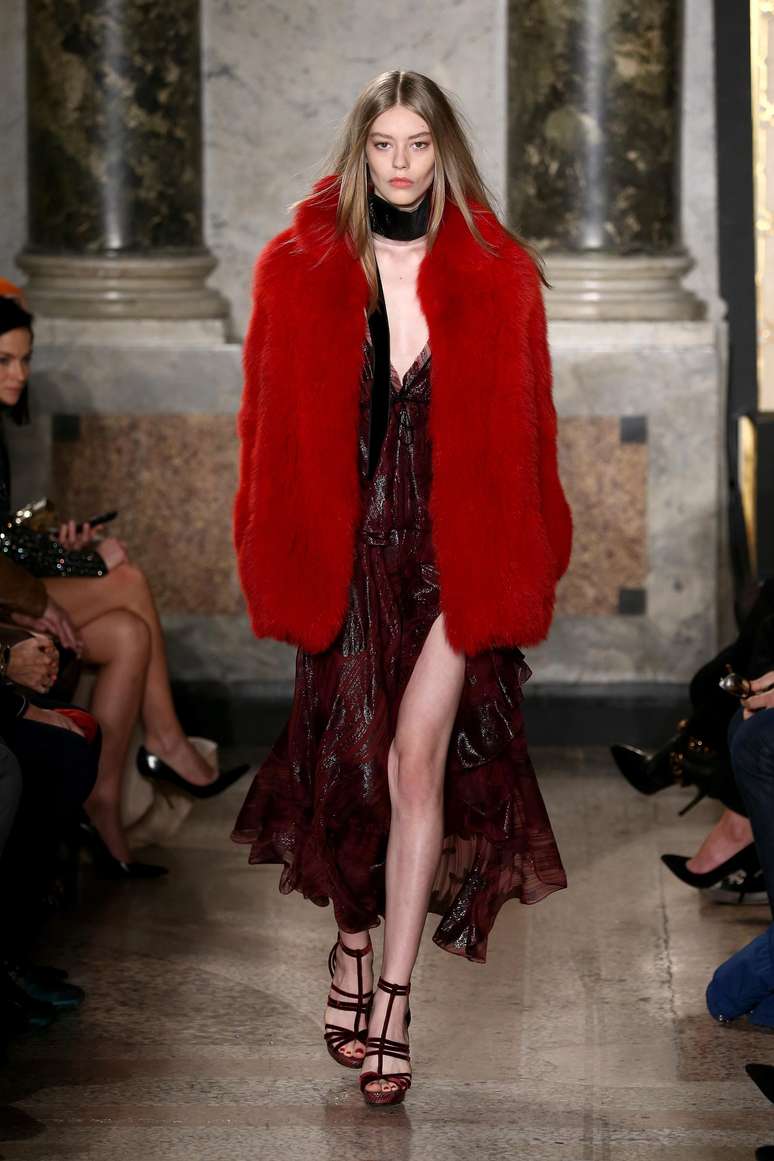 <p>O casaco vermelho de pele é da Pucci, que aposta na mistura com vestido longo de tecido leve</p>