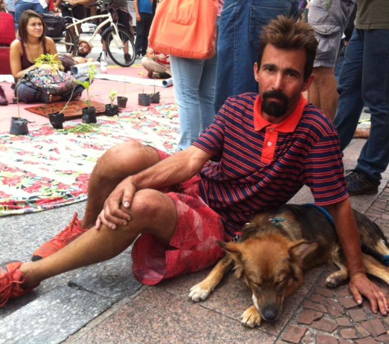 <p>Fábio ao lado de Chimarrão, cão com quem vive no parque Augusta; ele diz ter conseguido abandonar a droga e a cracolândia depois que passou morar na área</p>