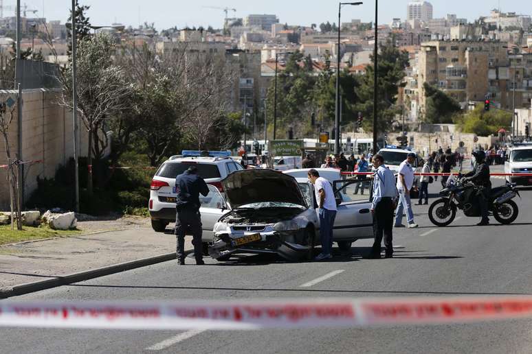 Policiais israelenses inspecionam carro utilizado por um motorista palestino para atropelar pedestres em parada de bonde em Jerusalém Oriental