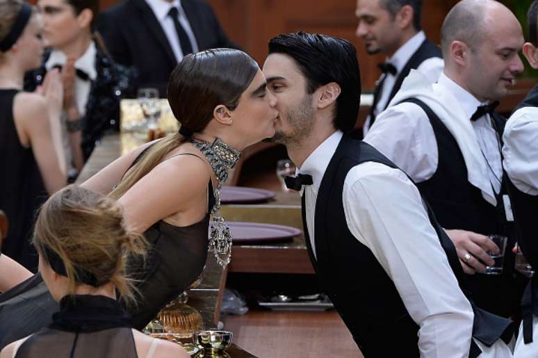 Com um beijo no rosto, Cara cumprimentou Baptiste Giabiconi, o muso de Lagerfeld que figurava como garçom
