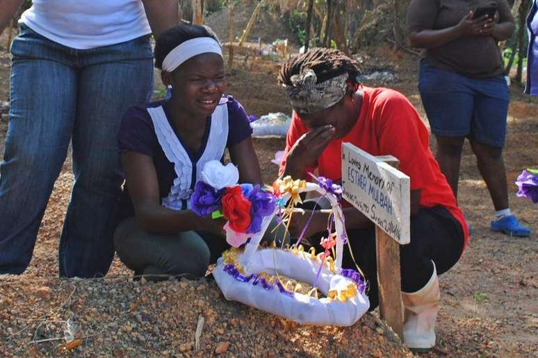 <p>Mulheres choram morte de parente em cemitério para vítimas do Ebola na Libéria</p>