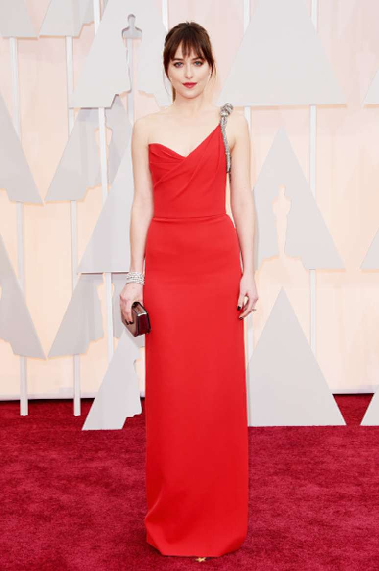 O vermelho é uma das cores mais sensuais que existem. A atriz Dakota Johnson, a Anastasia de Cinquenta Tons de Cinza, sabe disso e lascou um vestido vermelho tipo reto, com apenas uma alça, com uma superfenda na lateral. Alguém hostilizaria um vermelho assim?