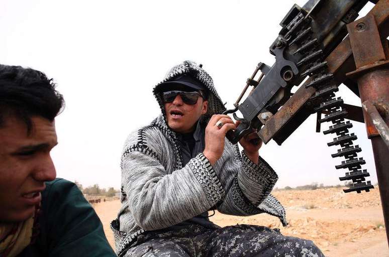Combatente do grupo Amanhecer Líbio segura arma perto de Sirte. 16/03/2015.