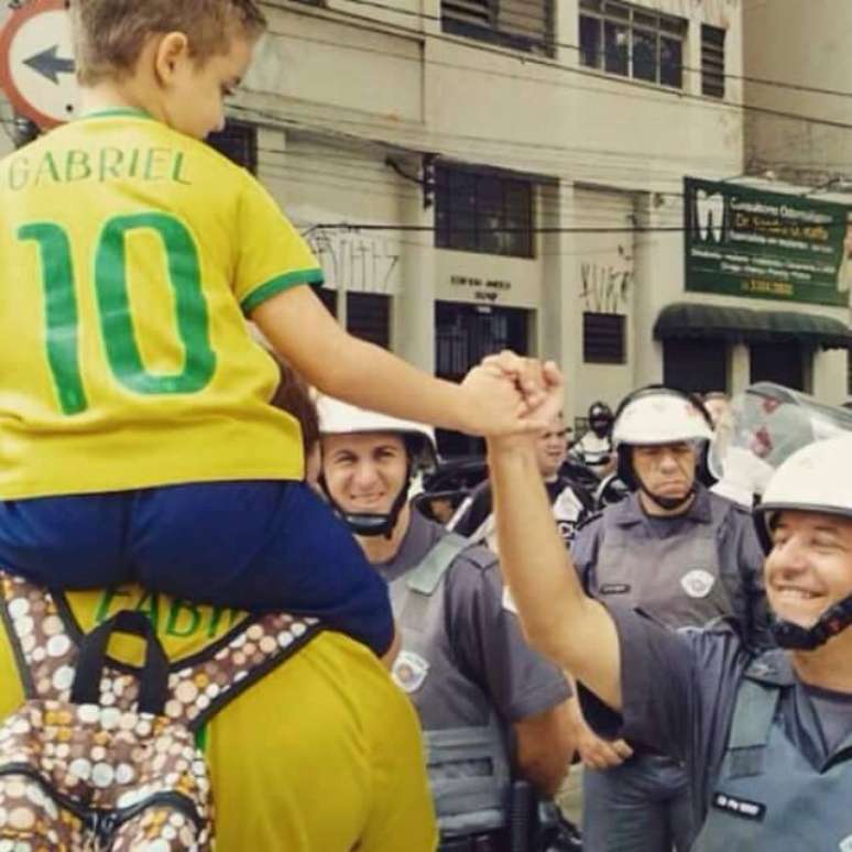 Garoto com a camisa do Brasil é cumprimentado por PM em São Paulo