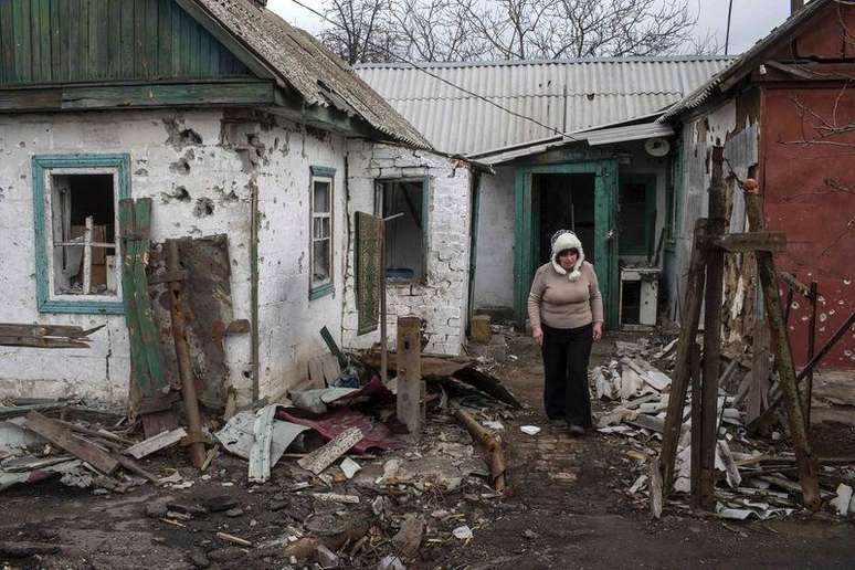 <p>Mulher caminha em casas destru&iacute;das na cidade de Debaltseve, nordeste de Donetsk, na Ucr&acirc;nia</p>