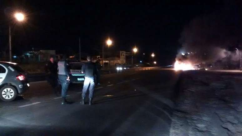 Policiais observam veículo incendiado em Parnamirim, na região metropolitana de Natal