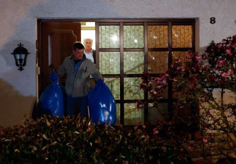 Policiais alemães saem com sacolas de casa que pertenceria a pais de copiloto em Montabaur.  26/03/2015.