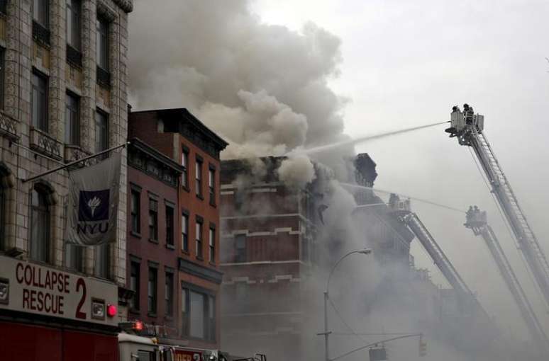 Bombeiros tentam apagar chamas em prédio em NY. 26/3/2015