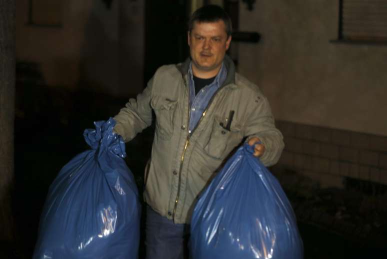 Um investigador carrega sacolas contendo objetos encontardos na casa da família do copiloto Andreas Lubitz em Montabaur, na Alemanha,em 26 de março