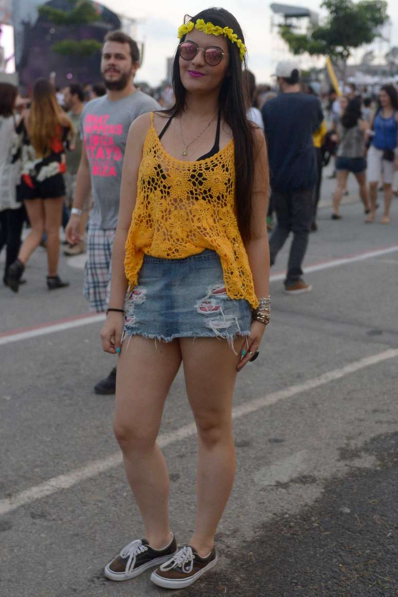 <p>Saia jeans com tecido desfiado, blusa de crochê com top à mostra e tênis foram as escolhas para o festival. Ela caprichou nos acessórios, com coroa de flores, muitas pulseiras e óculos de sol espelhados</p>