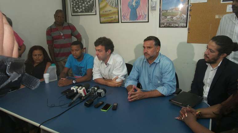 <p>Maicon de Moura (à esquerda, de camisa azul), filho de Elizabeth Moura, morta por um policial dentro da própria casa</p>