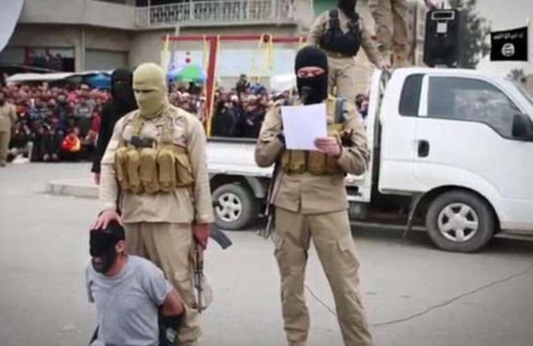 Gravação sem data mostra um militante jihadista mascarado, em frente a uma multidão, lendo aos quatros homens as condenações
