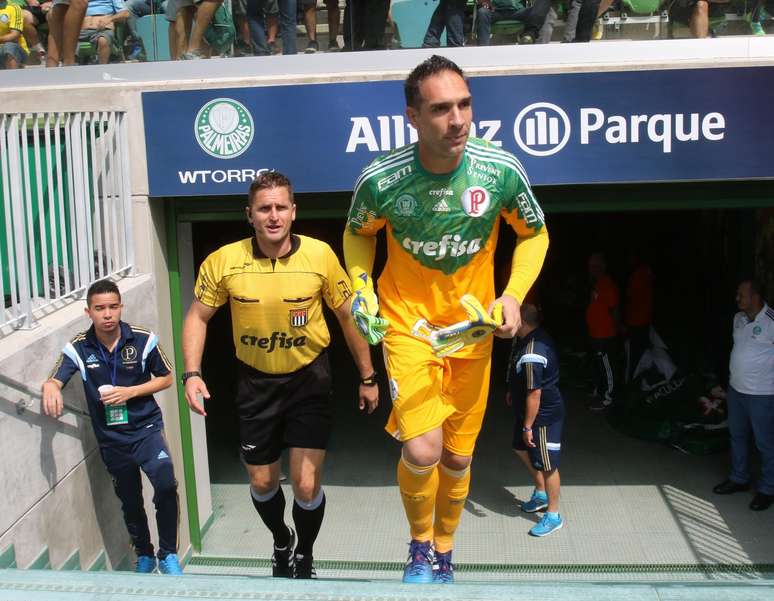 <p>Palmeirense Fernando Prass e árbitro Marcelo Rogério entram em campo com camisas patrocinadas pela Crefisa: fim da parceria com a FPF após recomendação da Fifa</p>