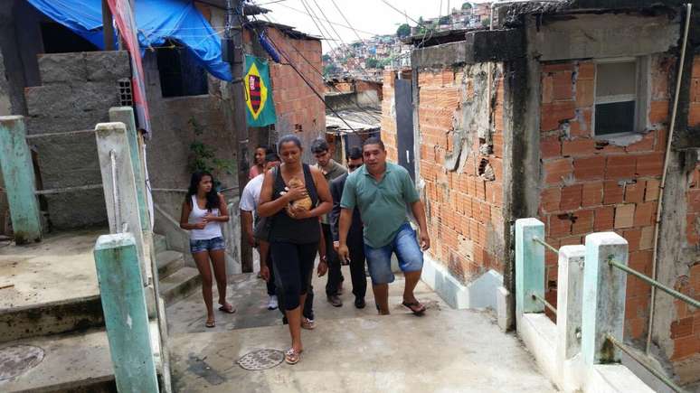 Familiares de Eduardo caminham junto à mãe durante a reconstituição do crime