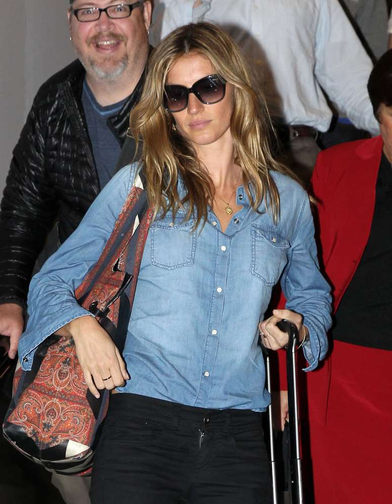 De camisa jeans e calça preta, Gisele Bündchen desembarca em aeroporto nos EUA