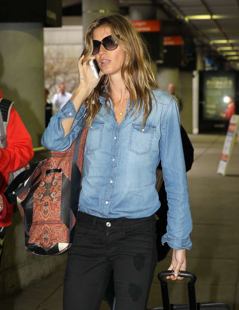 De camisa jeans e calça preta, Gisele Bündchen desembarca em aeroporto nos EUA