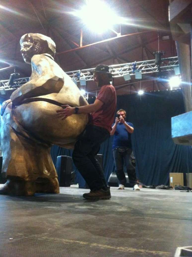 Em sua página no Facebook, banda publicou imagem de um ajudante de palco (roadie) acariciando a estátua dourada de Angela Merkel