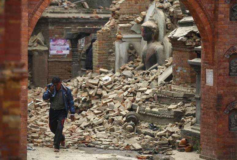 Homem chora em meio a escombros de prédios após terremoto no Nepal.