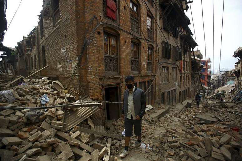 Homem caminha por escombros de casas destruídas em Bhaktapur, Nepal