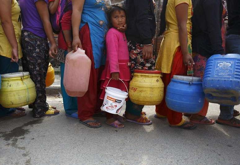 Menina espera em fila para encher recipiente com água perto dos abrigos improvisados em Katmandu, depois do terremoto de sábado. 28/04 2015.