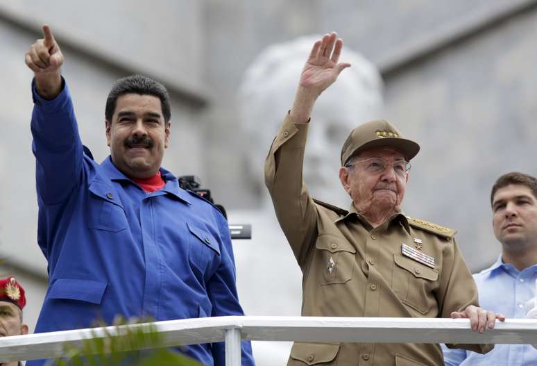 Com seu uniforme de general, Raúl Castro, com Maduro a seu lado, saudou milhares de pessoas que marcharam diante de uma tribuna na Praça da Revolução