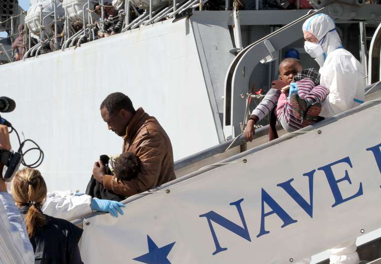 Imigrantes desembarcam da fragata da marinha italiana Bersagliere no porto de Reggio Calabria 