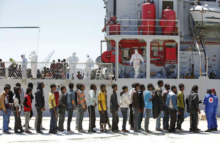 Imigrantes desembarcam do navio da Marinha italiana Vega, no porto siciliano de Augusta, sul da Itália