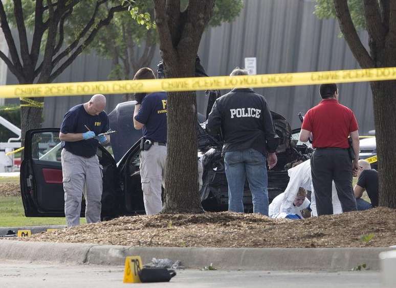 Investigadores da polícia e do FBI fazem buscas na área em torno do carro usado por atiradores que dispararam durante exposição em Garland, no Texas. 04/05/2015