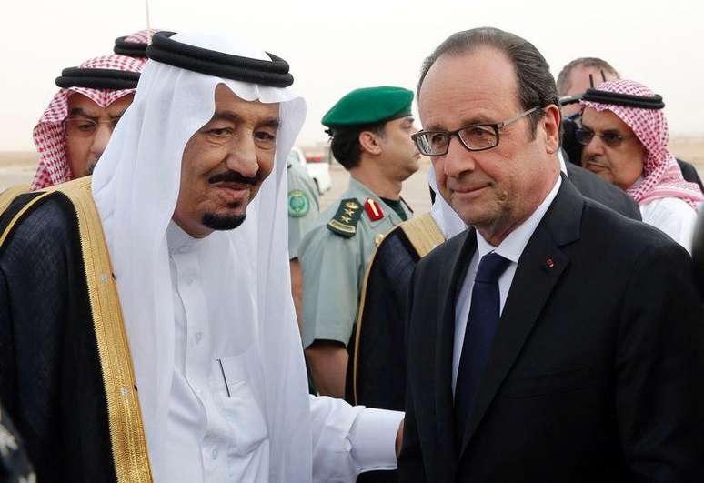 Presidente francês, François Hollande (dir), é cumprimentado pelo rei Salman, da Arábia Saudita, no aeroporto de Riad. 04/05/2015