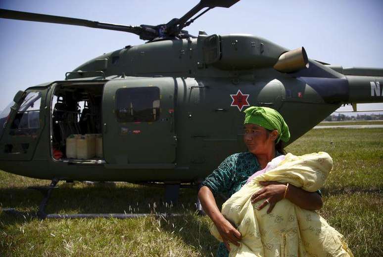 Mulher carregando seu filho após ser resgatada por helicóptero no distrito de Sindhupalchok.  03/05/2015