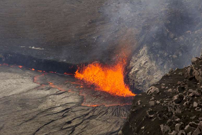 Um lago de lava é visto pelas pessoas no local - evento que não acontecia desde 1974